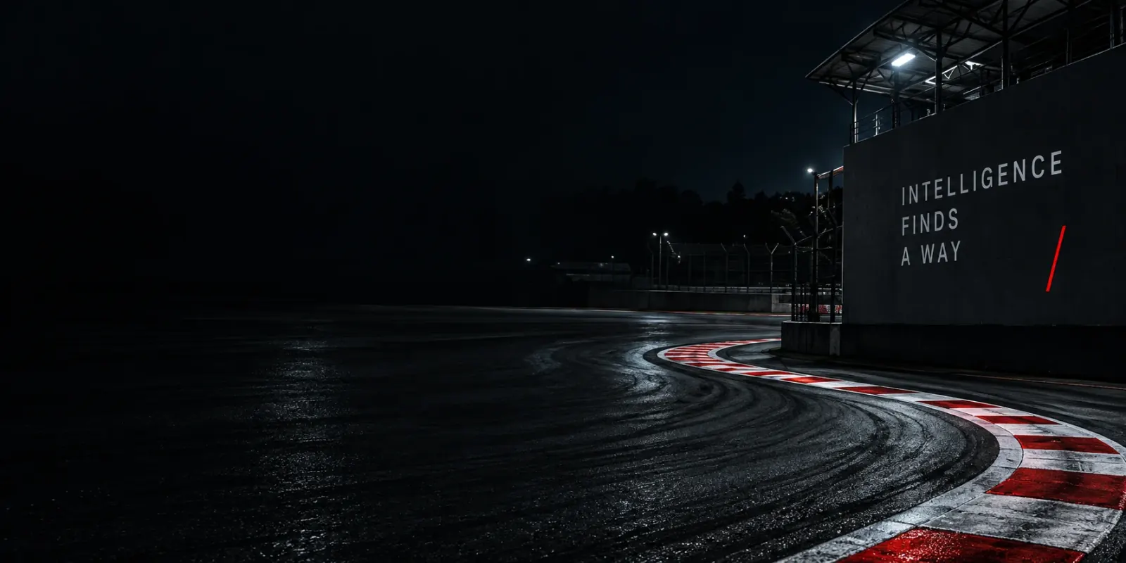 A night circuit with illuminated pit buildings and a wall reading Intelligence finds a way